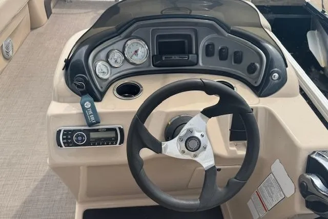 Slide: The Image of 2019 Sun Tracker Party Barge 20 DLX dashboard with steering wheel and gauges. - 10
