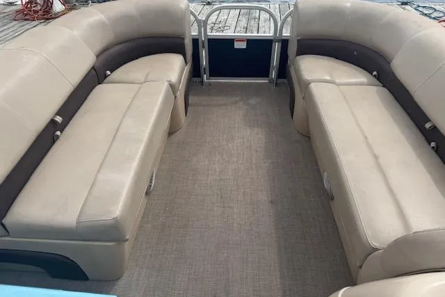 Slide: The Image of 2019 Sun Tracker Party Barge 20 DLX interior with beige seating and spacious layout. - 7