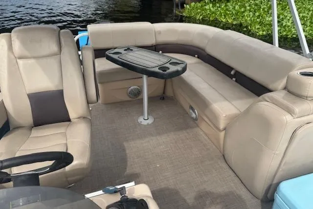 Slide: The Image of 2019 Sun Tracker Party Barge 20 DLX interior with beige seating and table. - 8