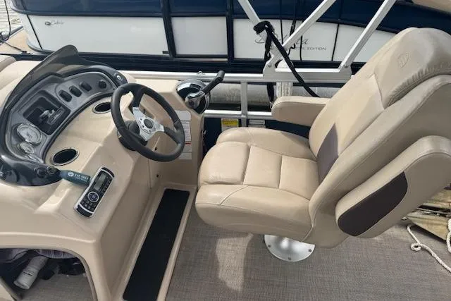 Slide: The Image of 2019 Sun Tracker Party Barge 20 DLX helm with beige captain's chair and steering console. - 9