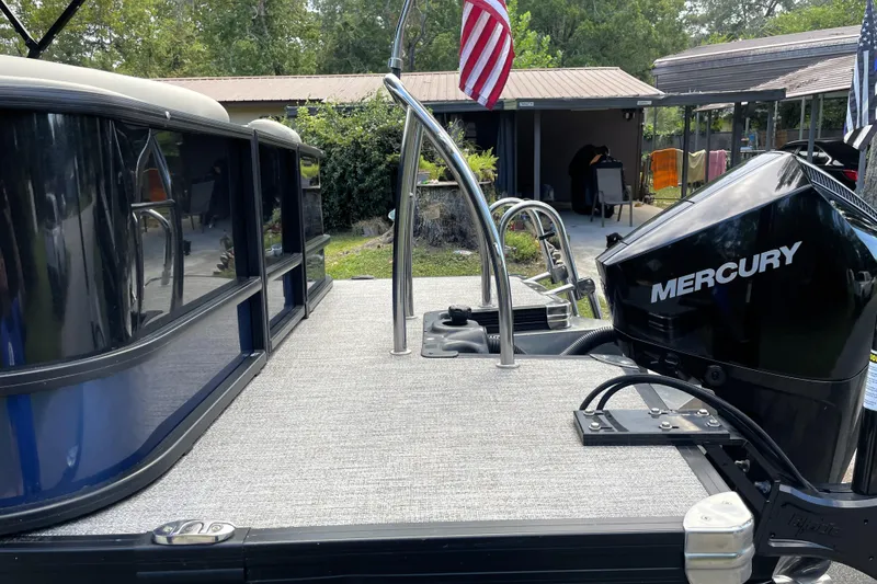 Slide: The Image of 2022 Barletta Cabrio 22QC pontoon boat with Mercury engine, docked outdoors. - 13