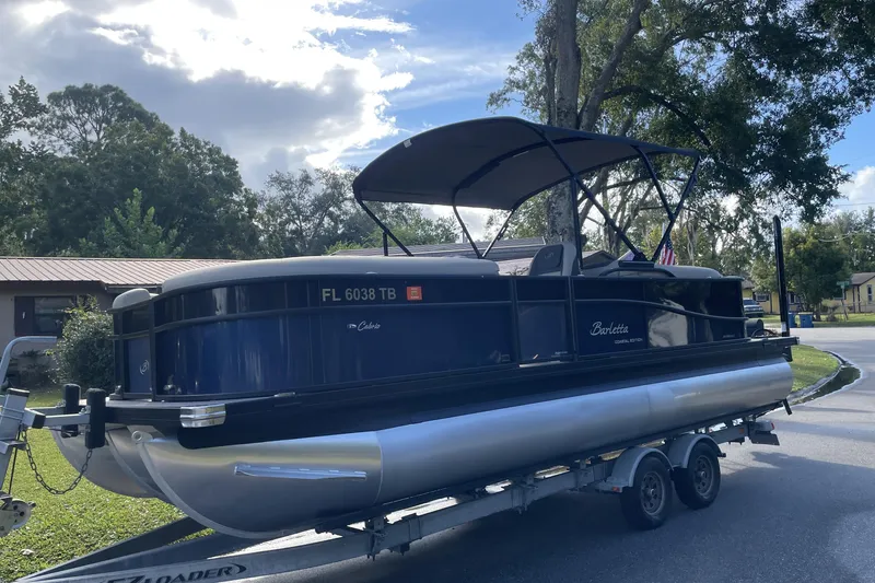 Slide: The Image of 2022 Barletta Cabrio 22QC pontoon boat on trailer, parked outdoors. - 3