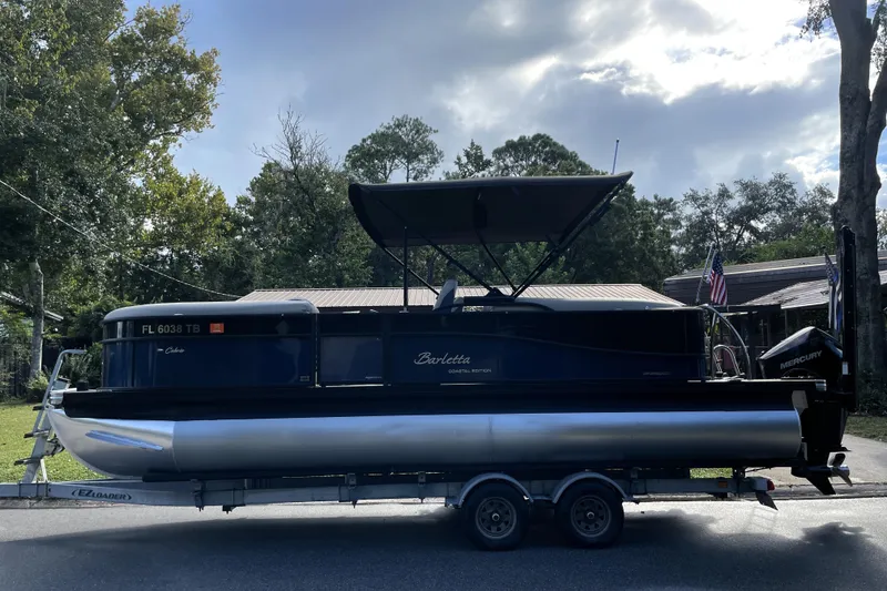 Slide: The Image of 2022 Barletta Cabrio 22QC pontoon boat on trailer, parked outdoors. - 4