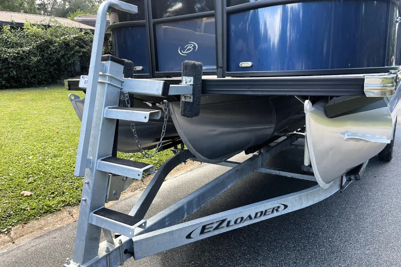 Slide: The Image of 2022 Barletta Cabrio 22QC pontoon boat on EZ Loader trailer, parked on a driveway. - 49