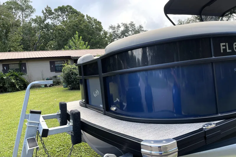 Slide: The Image of 2022 Barletta Cabrio 22QC pontoon boat on trailer, parked on grass near a house. - 7