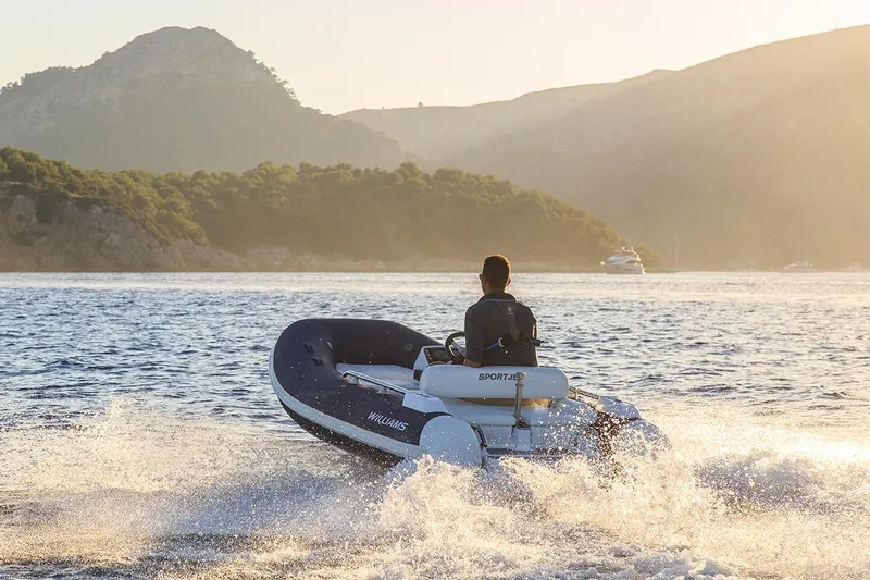 Slide: The Image of 2021 Williams Jet Tenders Sportjet 345 cruising on scenic water at sunset. - 2