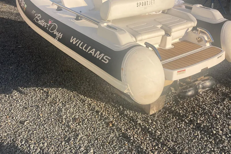 Slide: The Image of 2021 Williams Jet Tenders Sportjet 345 on gravel, showcasing rear design and branding. - 3