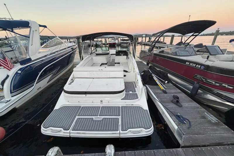 Slide: The Image of 2019 Sea Ray SDX 270 boat docked at sunset, surrounded by other boats. - 16