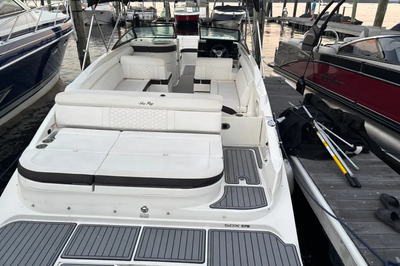 Slide: The Image of 2019 Sea Ray SDX 270 boat docked, featuring spacious seating and sleek design. - 17