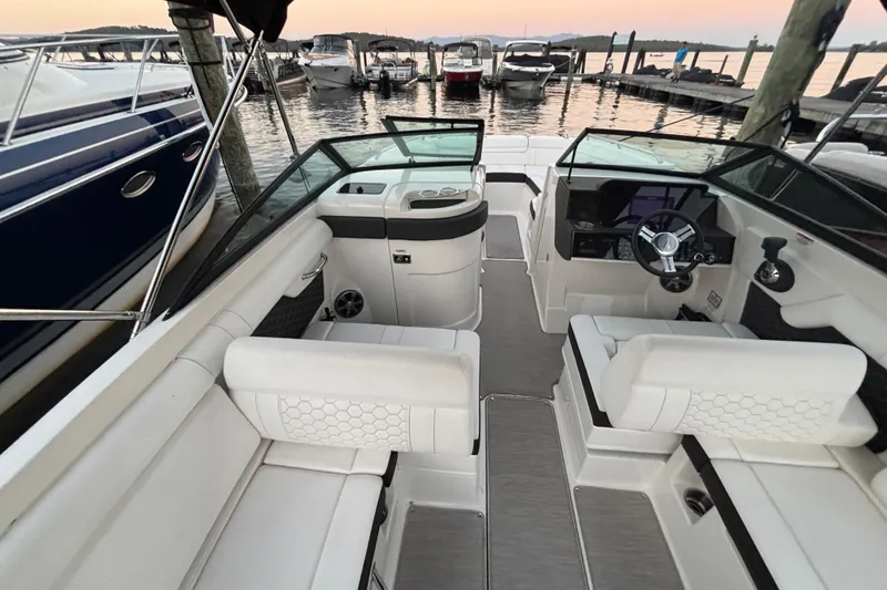 Slide: The Image of 2019 Sea Ray SDX 270 boat interior with white seating, docked at sunset. - 21