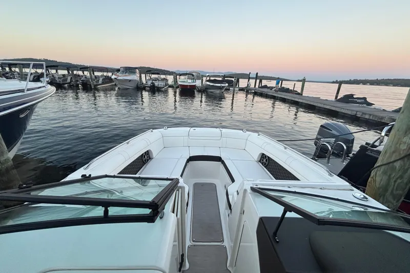 Slide: The Image of 2019 Sea Ray SDX 270 boat docked at sunset, with calm waters and surrounding boats. - 26