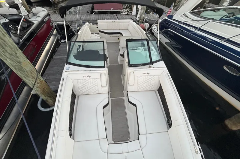 Slide: The Image of 2019 Sea Ray SDX 270 boat with spacious seating, docked between other boats. - 28