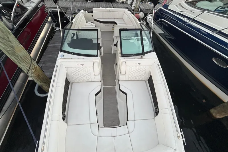 Slide: The Image of 2019 Sea Ray SDX 270 boat with white seating, docked alongside other boats. - 29