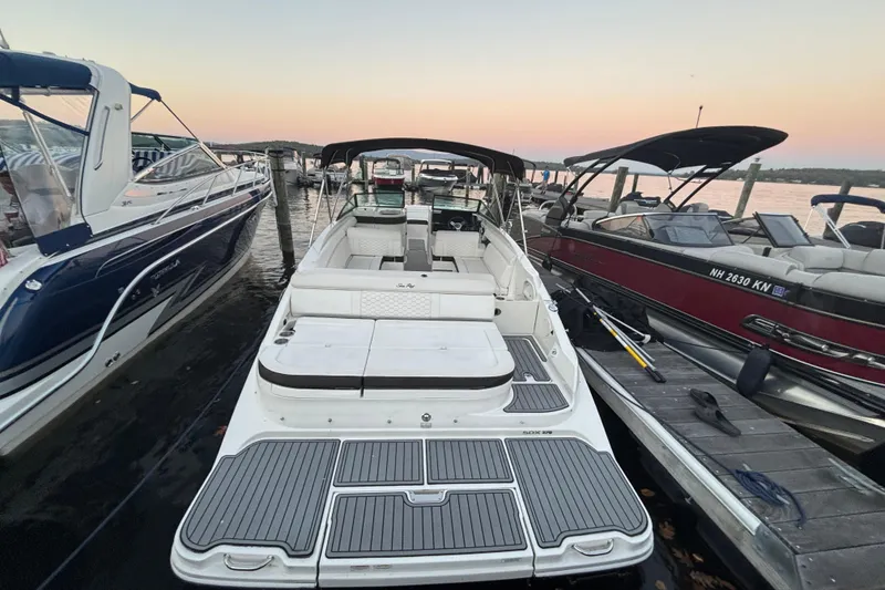 Slide: The Image of 2019 Sea Ray SDX 270 boat docked at sunset, surrounded by other boats. - 34