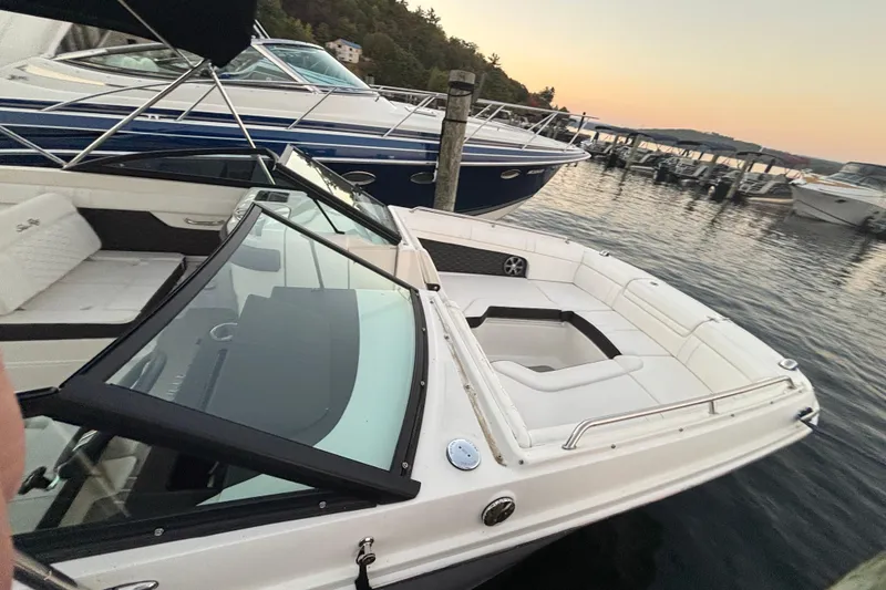 Slide: The Image of 2019 Sea Ray SDX 270 boat docked at sunset, featuring spacious seating and sleek design. - 35