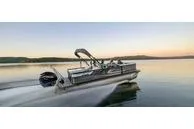 The Image of 2023 G3 Select 324 SS pontoon boat cruising on a serene lake at sunset. - 1