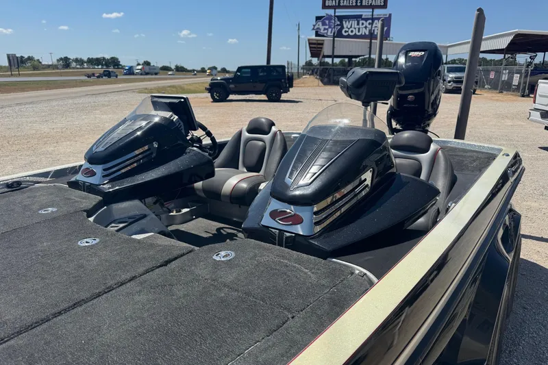 Slide: The Image of 2014 Ranger Z521 Comanche boat with dual consoles, parked near a highway. - 4