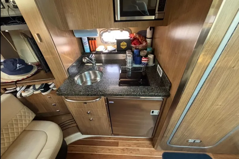 Slide: The Image of Compact kitchen area in a 2011 CHAPPARELL Signature 330 boat, featuring modern amenities. - 19