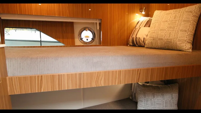 Slide: The Image of 2024 Cruisers Yachts 50 Cantius interior cabin with modern wooden finish and cozy bedding. - 50