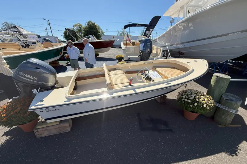 The Image of 2026 Rossiter 14 Sport boat displayed outdoors with Yamaha engine, surrounded by people and flowers. - 0