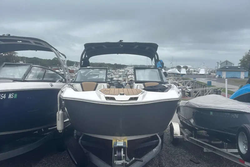 The Image of 2021 Yamaha Boats 252S on trailer at marina, cloudy sky background. - 1