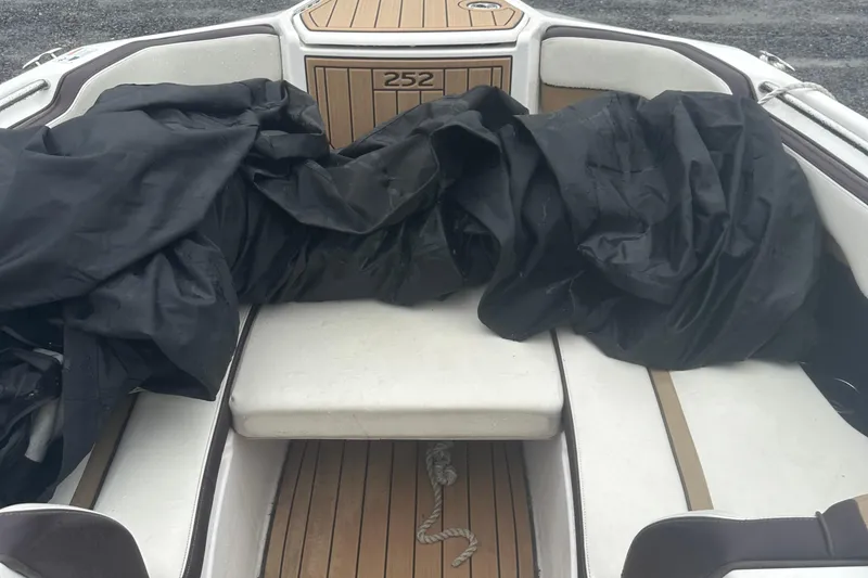 Slide: The Image of 2021 Yamaha Boats 252S interior with black cover and wooden deck. - 14