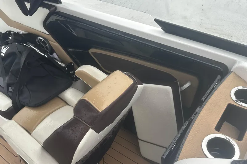 Slide: The Image of 2021 Yamaha Boats 252S interior with wet seats, cup holders, and a black bag. - 15