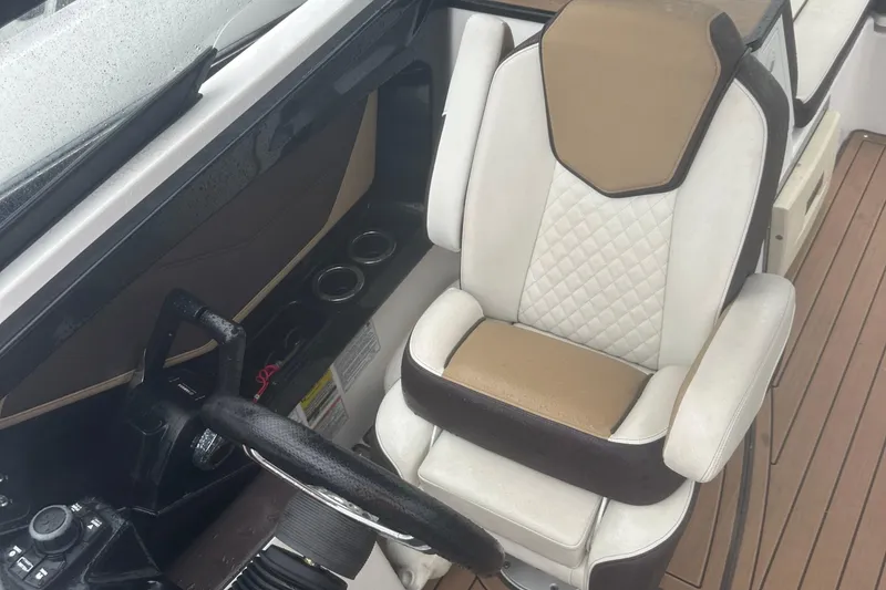 Slide: The Image of Captain's seat of 2021 Yamaha Boats 252S, featuring luxurious upholstery and modern controls. - 16