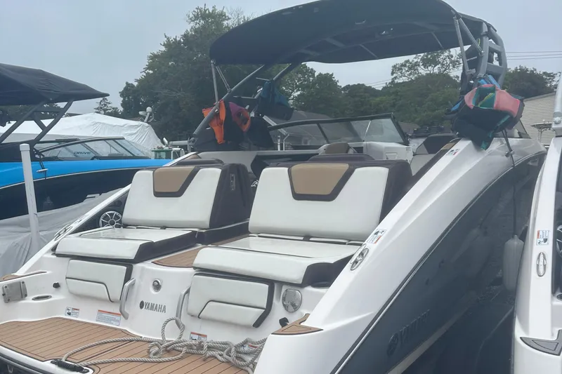 Slide: The Image of 2021 Yamaha Boats 252S with cushioned seating and sleek design, docked outdoors. - 3