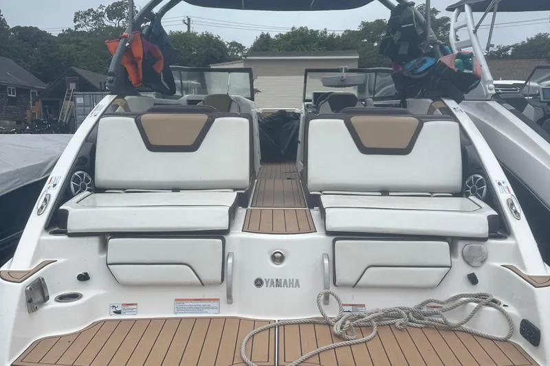 Slide: The Image of 2021 Yamaha Boats 252S with white seating and teak flooring, docked outdoors. - 6