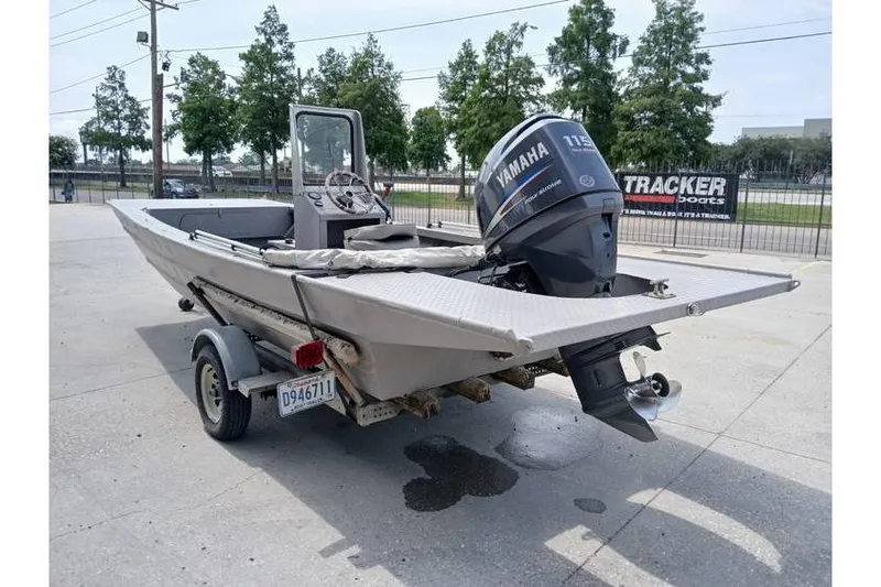 Slide: The Image of Custom 1983 boat with Yamaha 115 outboard motor on trailer, parked outdoors. - 2