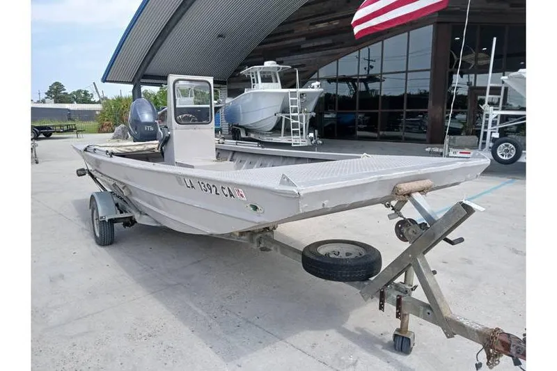 Slide: The Image of Custom 1983 boat on trailer with American flag, parked outside a showroom. - 4