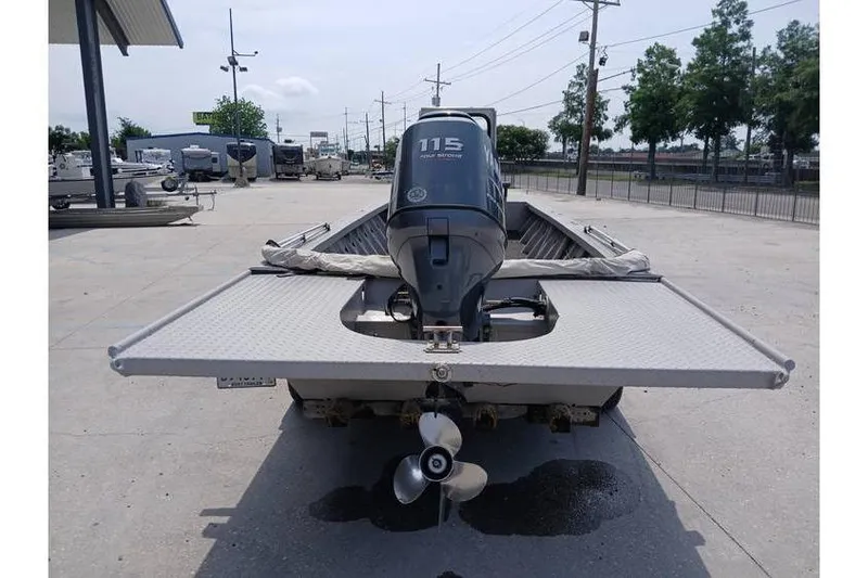 Slide: The Image of Custom 1983 boat with 115 horsepower outboard motor, parked outdoors. - 6