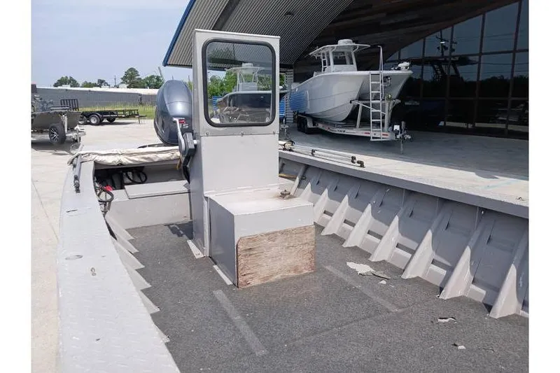 Slide: The Image of Open deck of a 1983 Custom model 18 boat, parked near a showroom. - 9