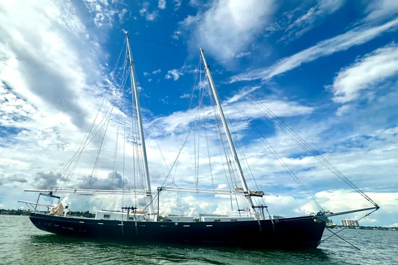 The Image of Schooner Leopard 1994 sailing under a vibrant blue sky with scattered clouds. - 0
