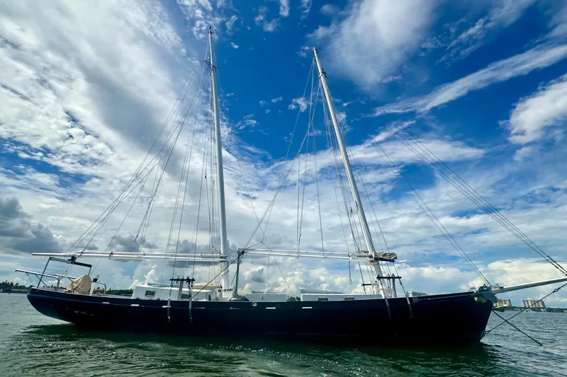 The Image of Schooner Leopard 1994 sailing under a vibrant blue sky with scattered clouds. - 1