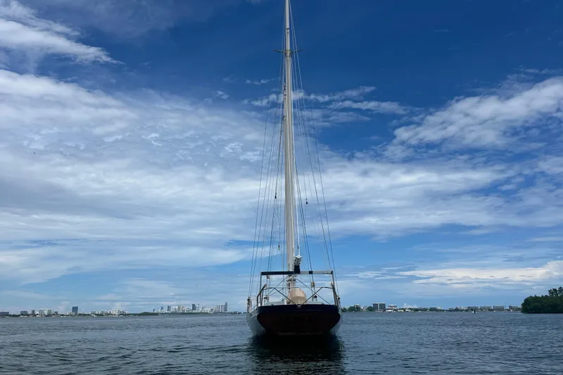 Slide: The Image of Schooner Leopard sailboat on calm water under a blue sky, city skyline in background. - 12