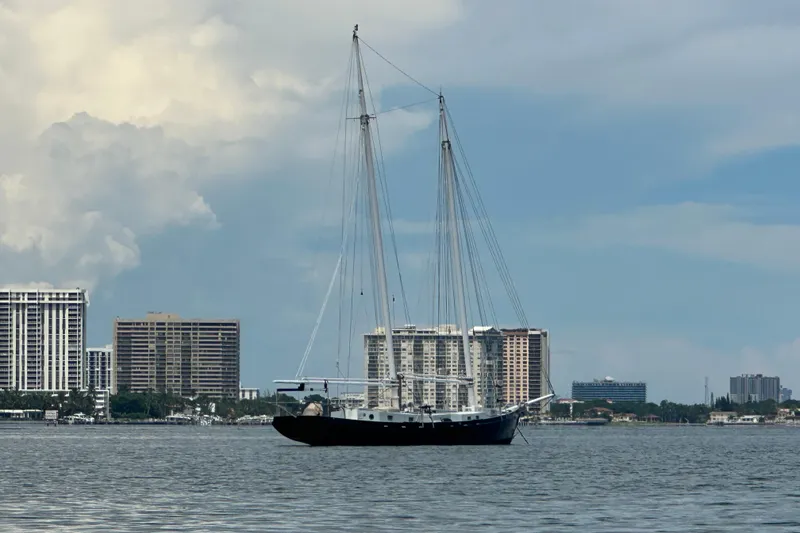 Slide: The Image of Schooner Leopard 1994 sailing near city skyline under cloudy sky. - 20