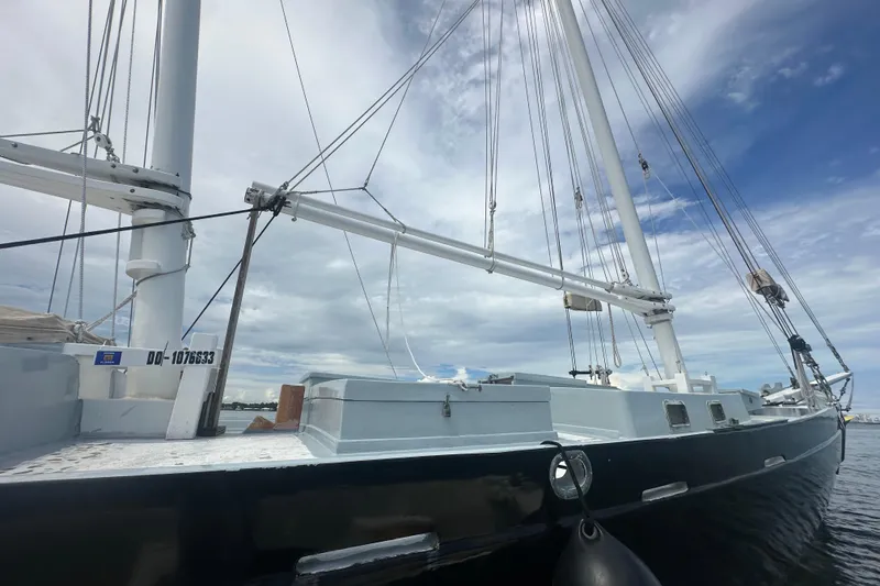 Slide: The Image of Schooner Leopard 1994 sailboat with tall masts against a cloudy sky. - 23