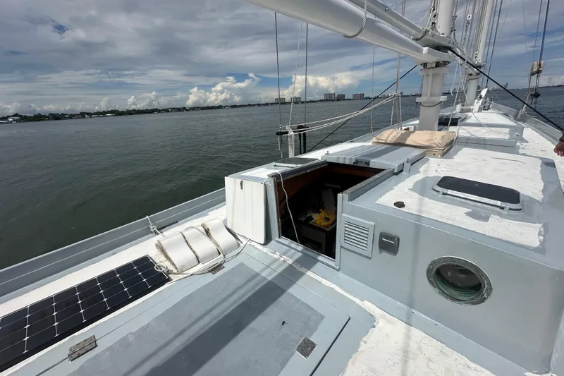 Slide: The Image of Schooner Leopard 1994 sailboat deck with solar panel, open hatch, and ocean view. - 30