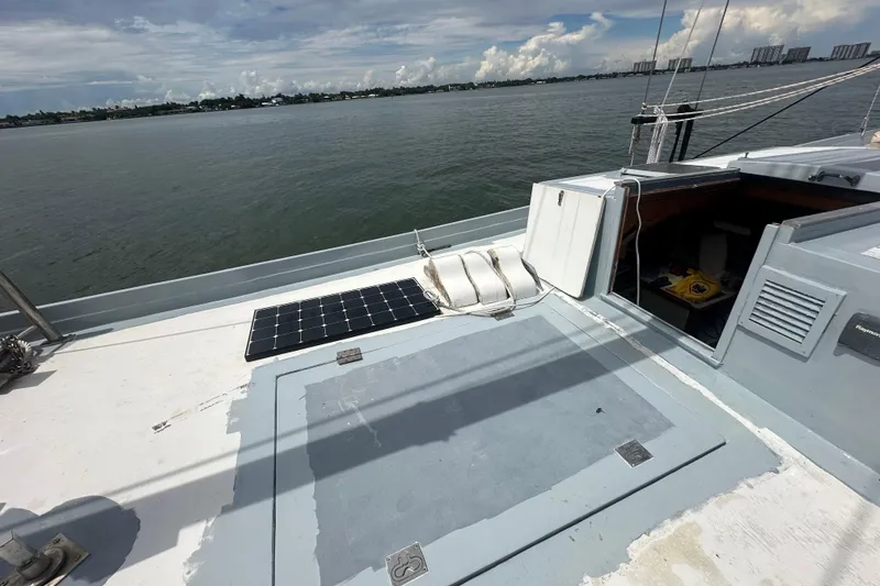 Slide: The Image of Schooner Leopard 1994 deck with solar panel, overlooking calm waters and distant shoreline. - 31