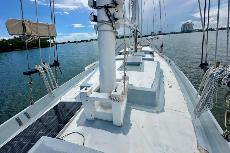 Slide: The Image of Schooner Leopard 1994 sailboat deck with rigging, moored in calm waters under a blue sky. - 32