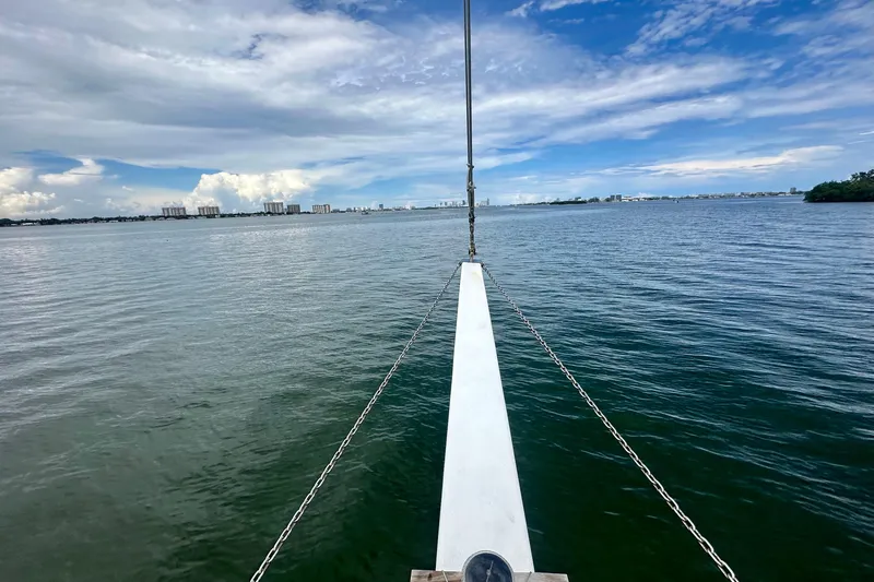 Slide: The Image of Bow view from 1994 Pilot Schooner Leopard sailing on calm waters under a partly cloudy sky. - 36