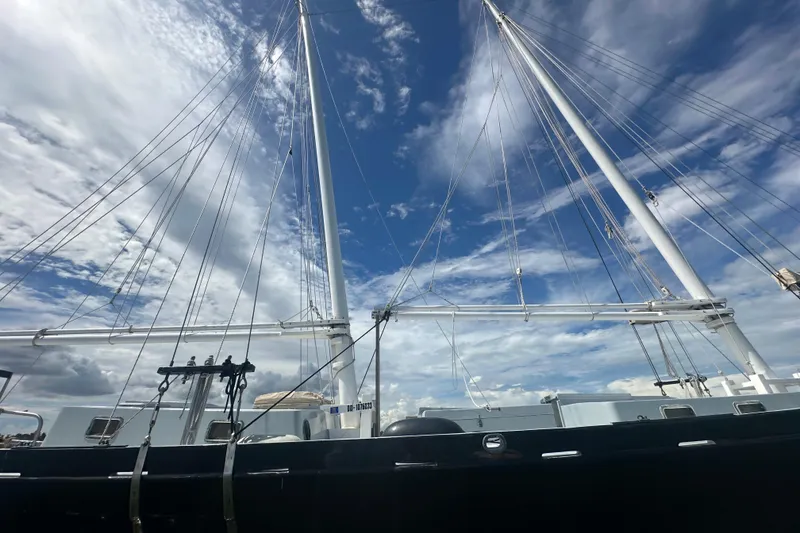 Slide: The Image of Schooner Leopard 1994 with tall masts against a vibrant blue sky. - 4
