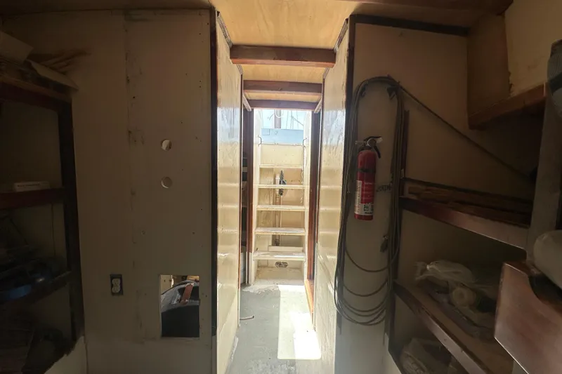 Slide: The Image of Interior of 1994 Pilot Schooner Leopard, featuring narrow passageway and storage shelves. - 55