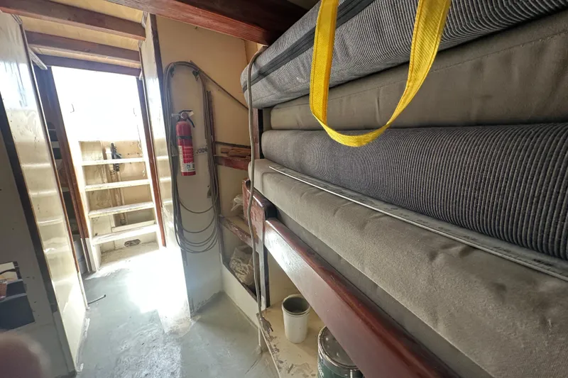 Slide: The Image of Interior of 1994 Pilot Schooner Leopard with stacked cushions and fire extinguisher. - 56