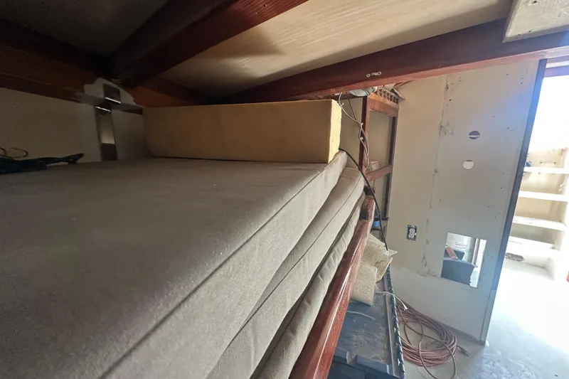 Slide: The Image of Interior view of 1994 Pilot Schooner Leopard with stacked cushions and visible wiring. - 58