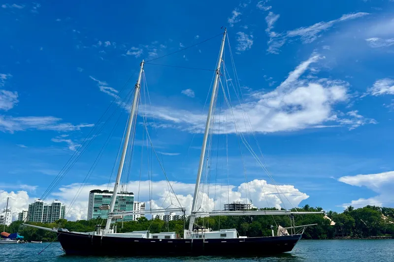 Slide: The Image of Schooner Leopard 1994 sailing on a sunny day with cityscape background. - 6