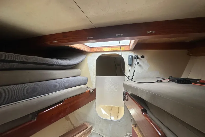 Slide: The Image of Interior cabin of 1994 Pilot Schooner Leopard with stacked cushions and communication equipment. - 60