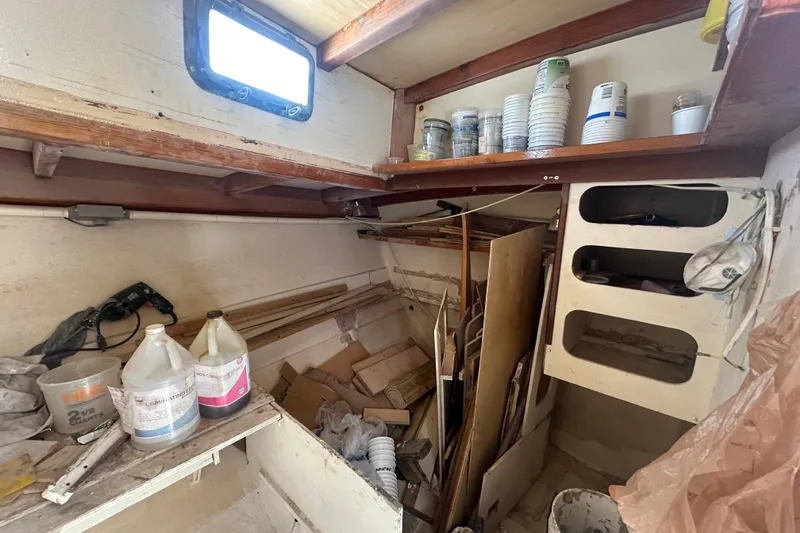 Slide: The Image of Interior of 1994 Pilot Schooner Leopard, showing storage area with supplies and wooden shelves. - 68